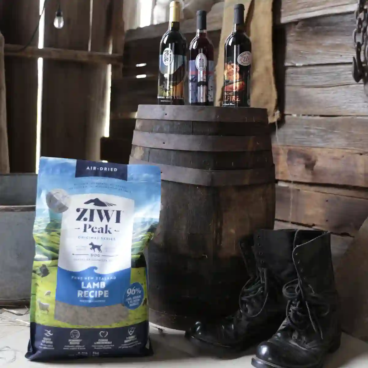 Production shot from commercial video shoot of dogfood bag in barn next to barrel with wine bottles.