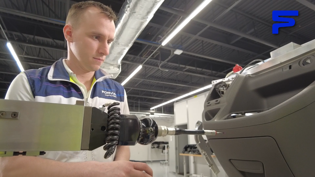 Man working piece of machinery, measuring thickness of plastic