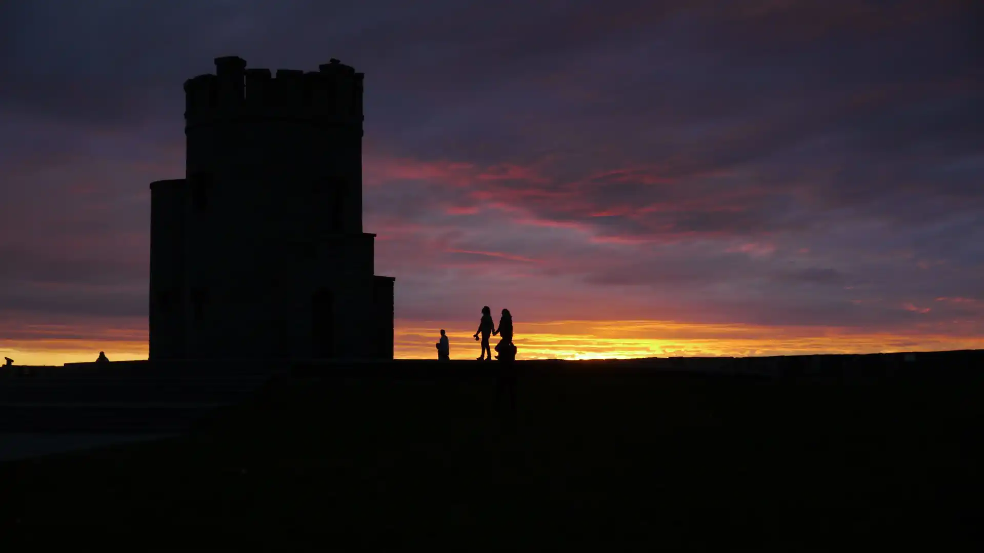 Kansas city video production company, Outpost Worldwide, shoots a silhouette of a family outside of a stone turret tower at sunset